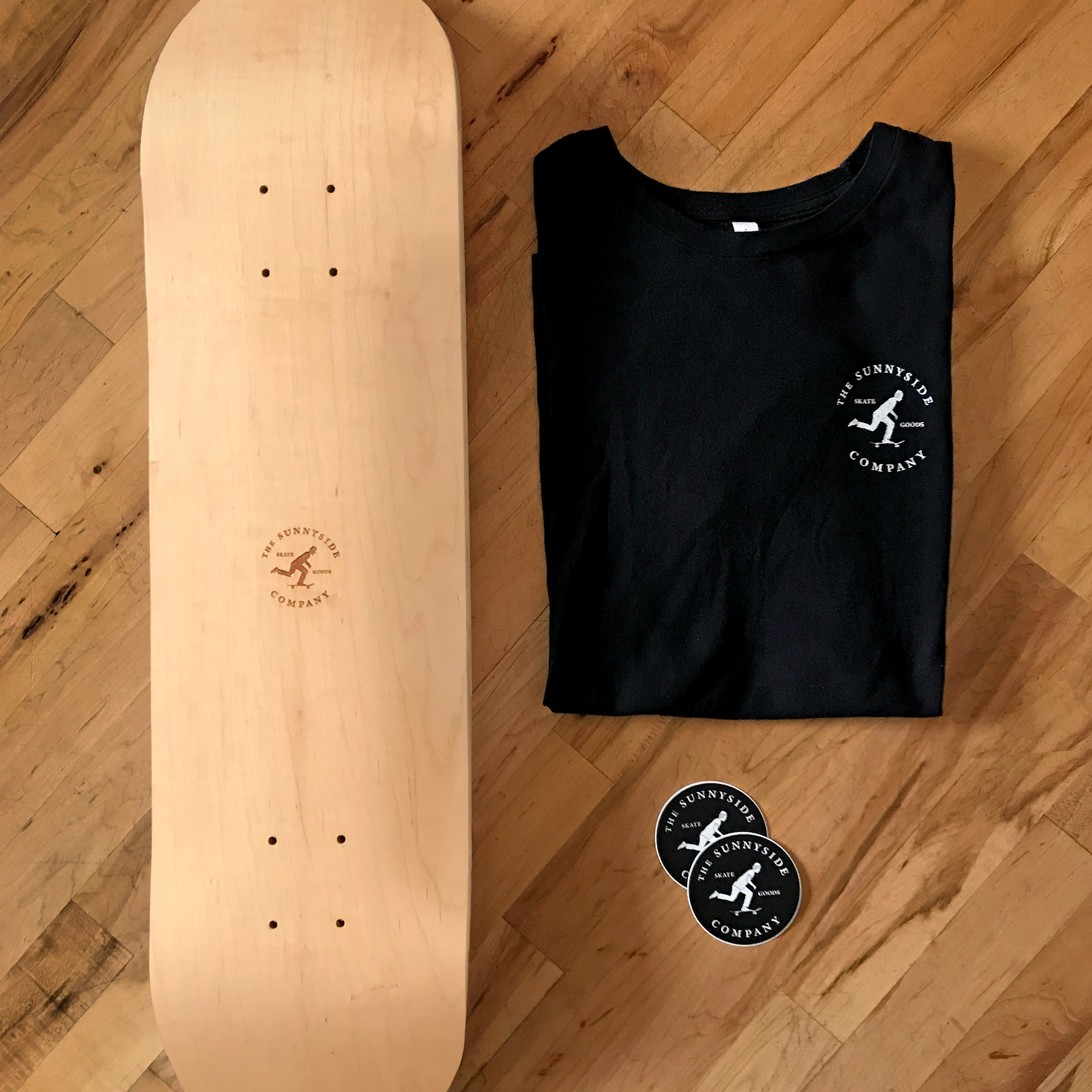Skateboard deck, t-shirt, and stickers featuring logo of skateboarder pushing
